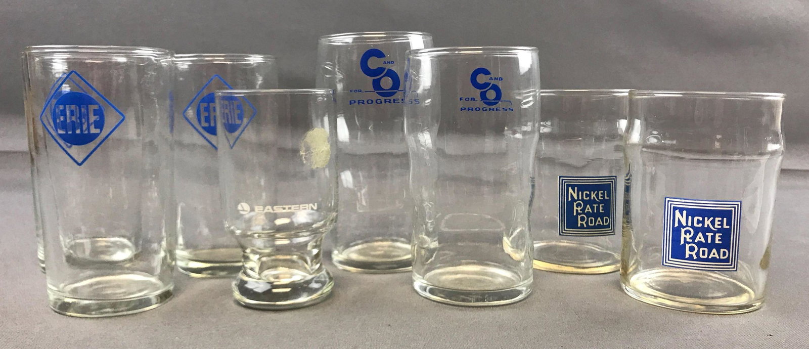 Group of Vintage railroad line glasses: Includes Erie, eastern, c&o, Nickel plate road. Tallest is 5 inches. A couple of small chips at the top of one.