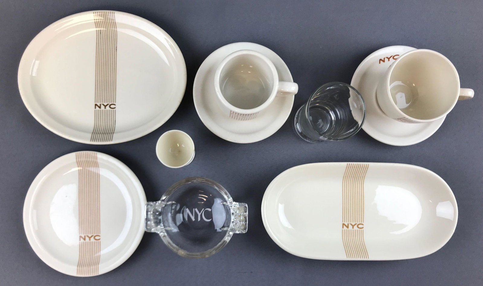 Vintage New York Central Dishes and glassware: 10 pieces. Coffee mug, tea cup, saucers, egg cup, plates and more. Egg cup has small chip. Largest 10x5 inches.