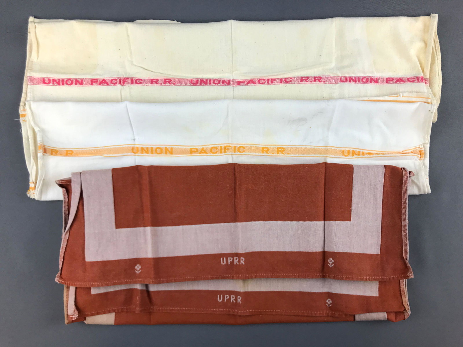 Group of 4 Union Pacific linens: 2 hand towels, 2 napkins. Napkin is 19x19 inches. Some stains and wear.