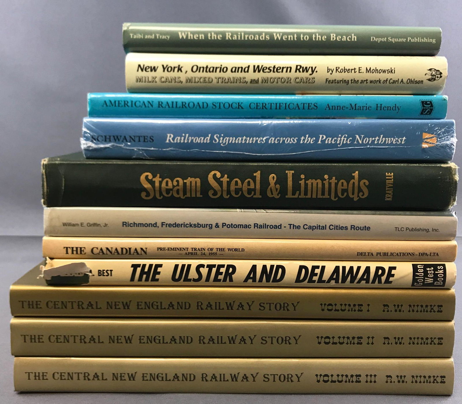 Group of 11 railroad books: Includes three volumes the central New England railway story, steam steel and limiteds, American railroad stock certificates, and more