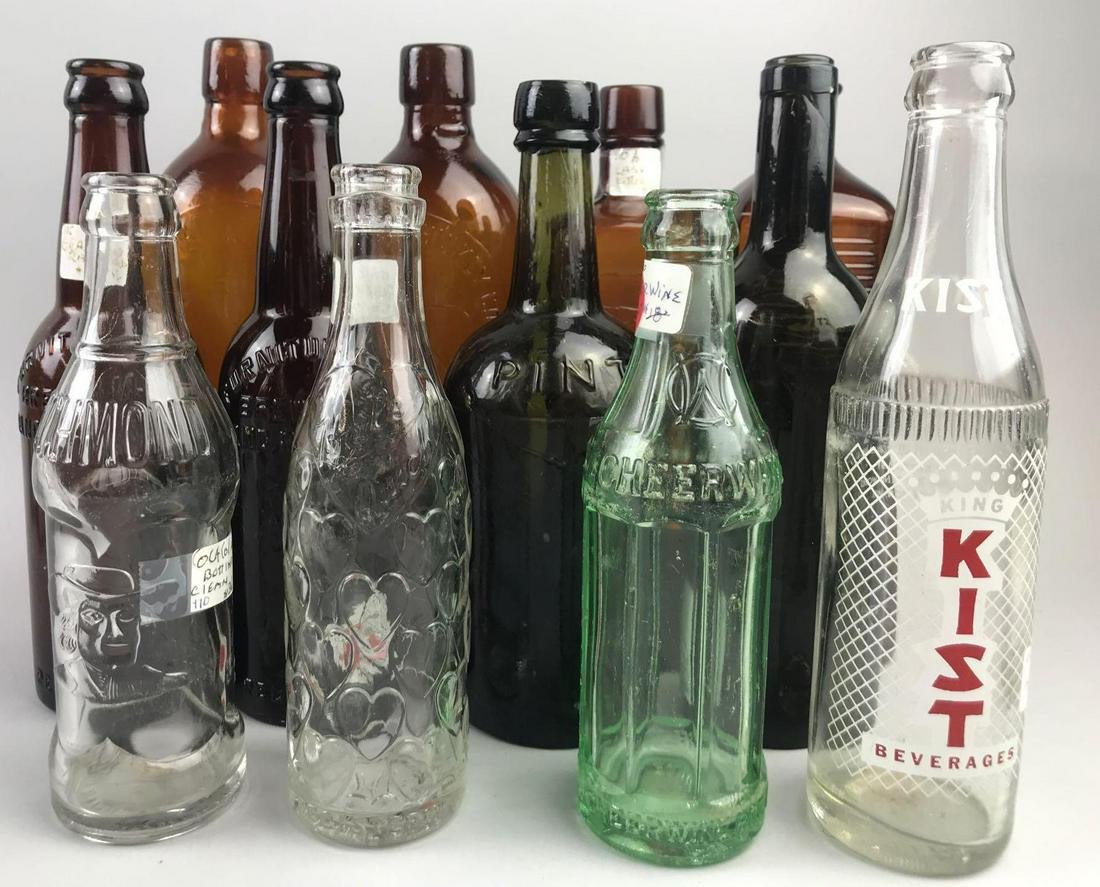 Group of 12 vintage & antique glass bottles: Clear, green, amber, and brown. Includes The Duffy Malt Whiskey Company-Rochester, NY, Furniture City Brewing Company-Grand Rapids, MI, Coca-Cola Bottling-Richmond, IN, and more.