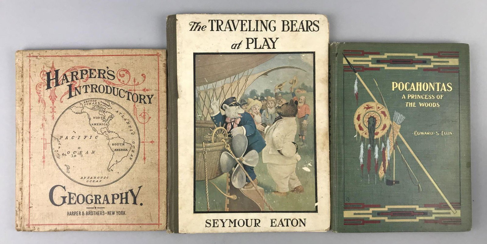 Group of 3 antique (1877-1914) hardcover books: Harpers Introductory Geography, The Traveling Bears at Play, and Pocahontas A Princess of the Woods. Largest is 8.25x11 inches