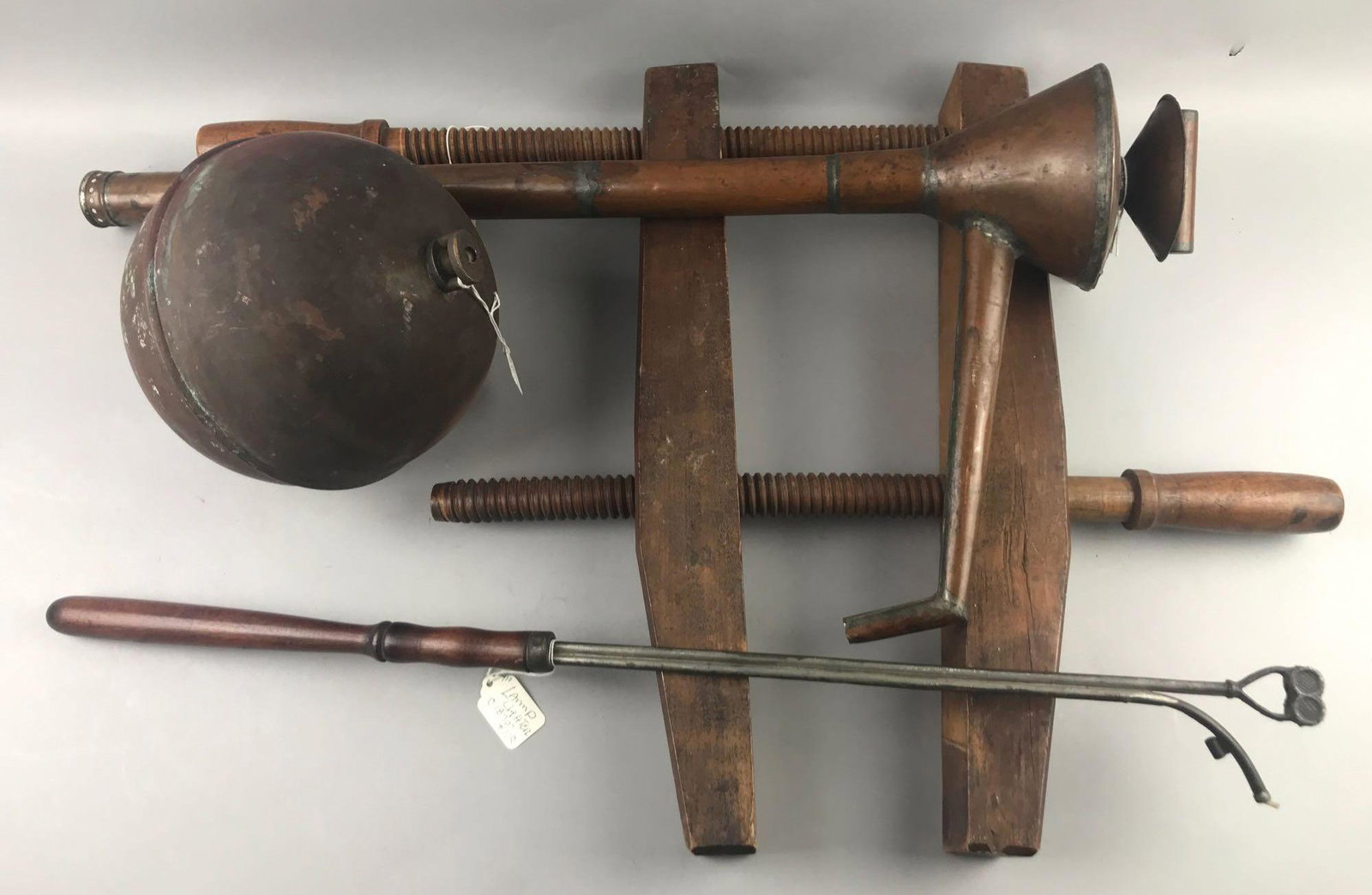Group of 4 antique/vintage wood and metal tools: Largest is 14x29 inches. Lamp lighter, copper ball float, copper filter/pump, and wood clamp.