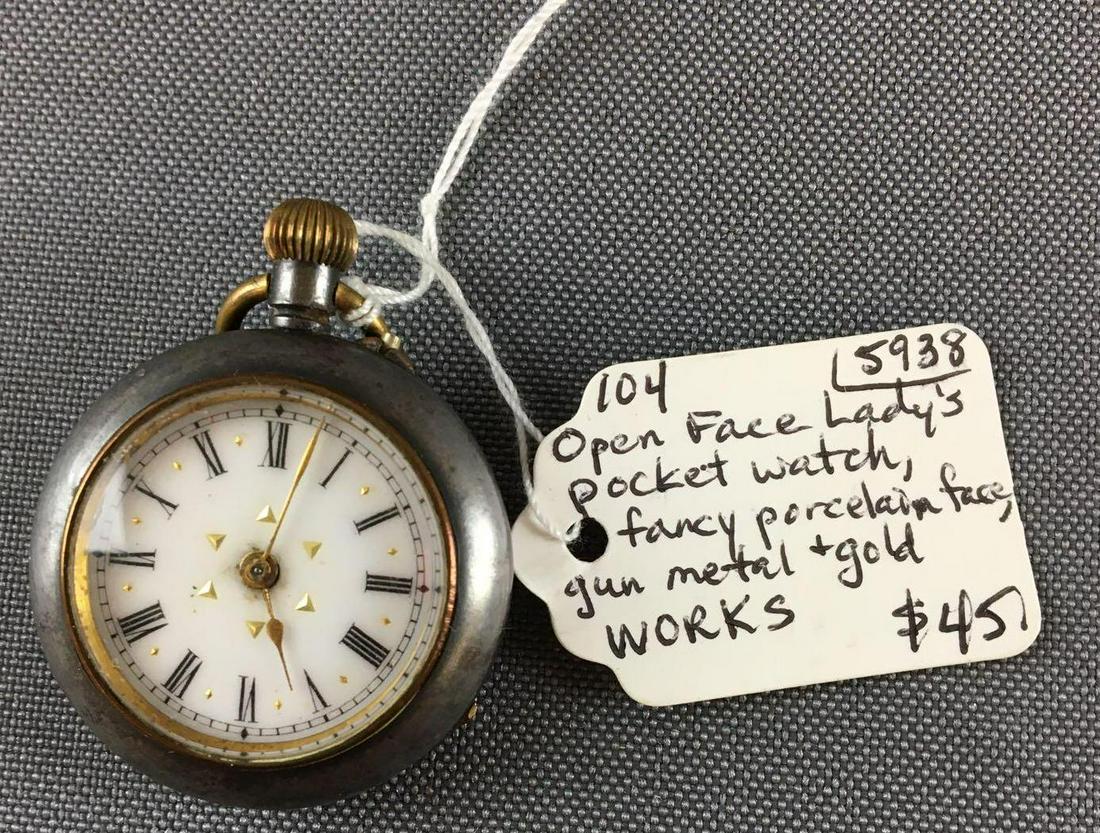 Antique Open Face Lady?s Pocket Watch: Fancy porcelain face, Gun metal and gold, in working condition 1 1/4 inch