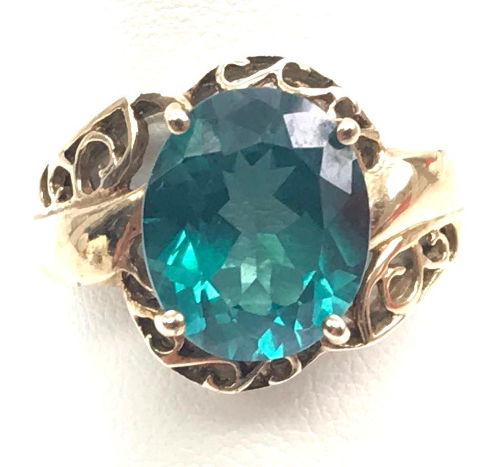 10k Yellow Gold Green Topaz Ring: Size 7.5; An exceptionally good-looking emerald blue-green oval cut topaz solitaire (11mm x 8mm) framed by a 10k yellow gold openwork border and shank; 4.7g