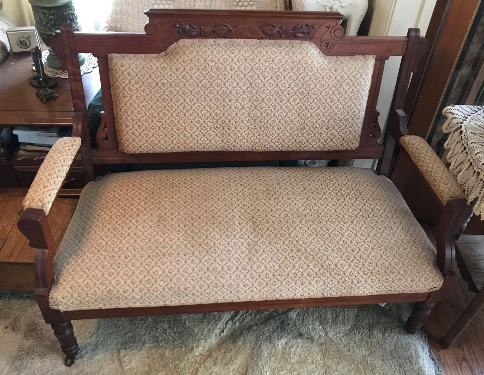 Antique Upholstered Settee/Loveseat: Upholstered settee/loveseat measures 48 x 24 x 38 inches w/casters. Shipping is not available for this lot. Pick up only. (Large or heavy items can be transferred to our Gallery for an additional fee.