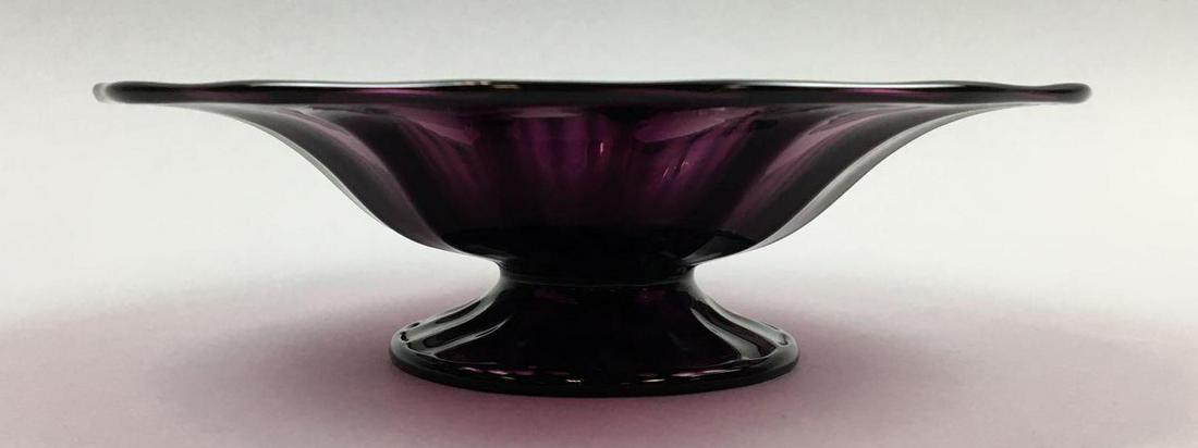 Steuben Amethyst Ribbed Footed Bowl: This Steuben rich Amethyst Ribbed Footed Bowl measures 2-1/4 x 8 inches. There is a wonderful, thick ribbing to the piece. The top edge and base have rolled rims; The piece is unsigned; has a pontil; 