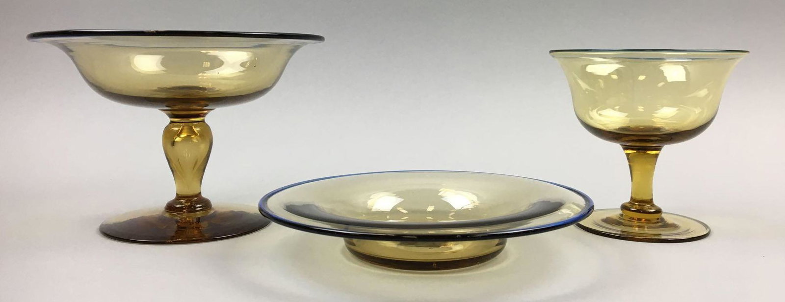 Group of 3 : Steuben Amber Glassware: This Steuben Collection consists of a 4 x 6 inch Steuben Amber w/Celeste Blue Footed Compote; 1 x 6 inch Amber w/ Celeste Blue Underplate; and a 3-7/8 x 4 inch Amber Sherbet. All in very good,vintage 