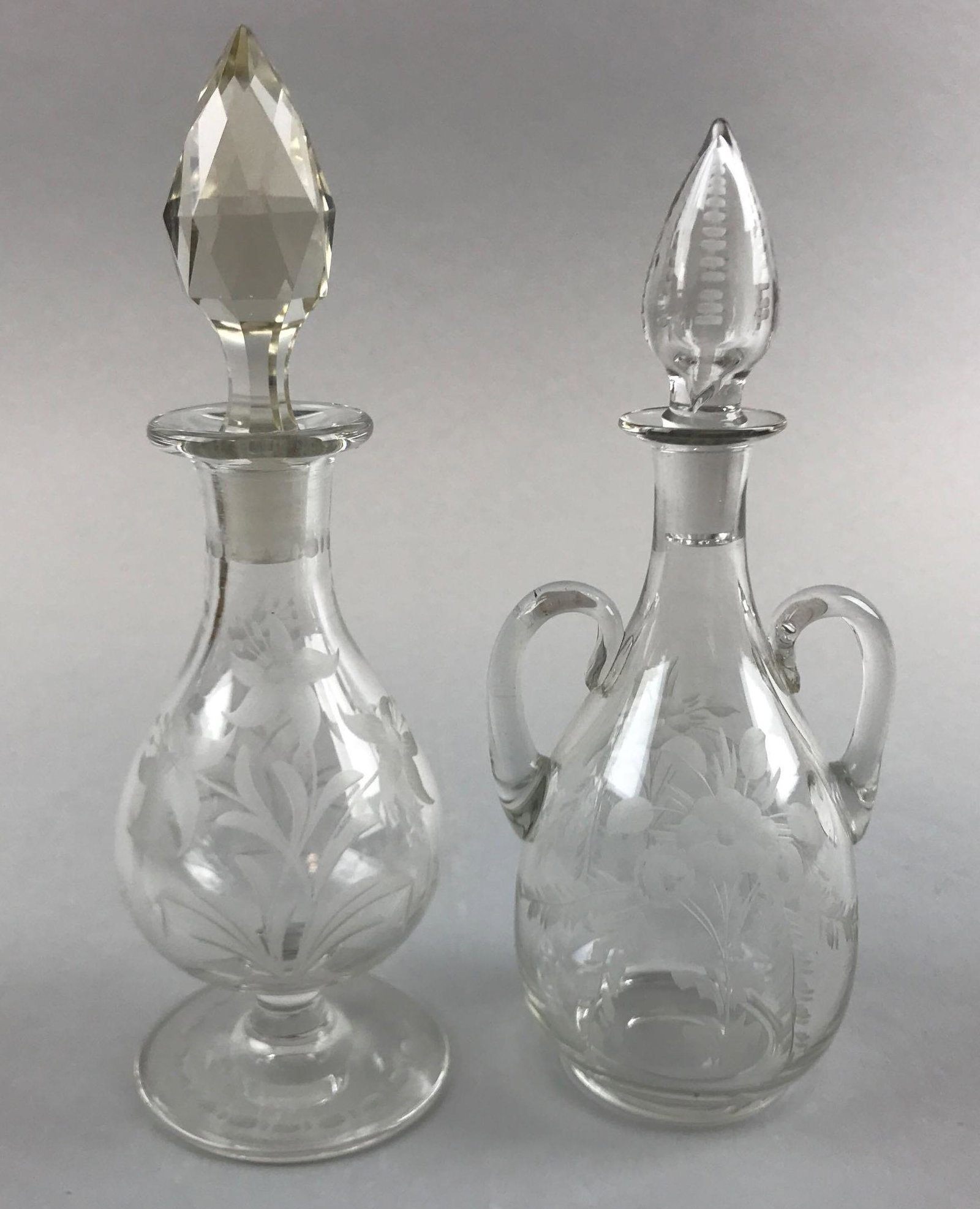 Lot of 2 : American Brilliant Period Cut Glass Floral: Taller bottle with stopper measures 7 1/4 inches. The bottles in this lot are faintly marked - one is Pitkin and Brooks, and the other is Hawkes. Both bottles exhibit some minor wear consistent with a