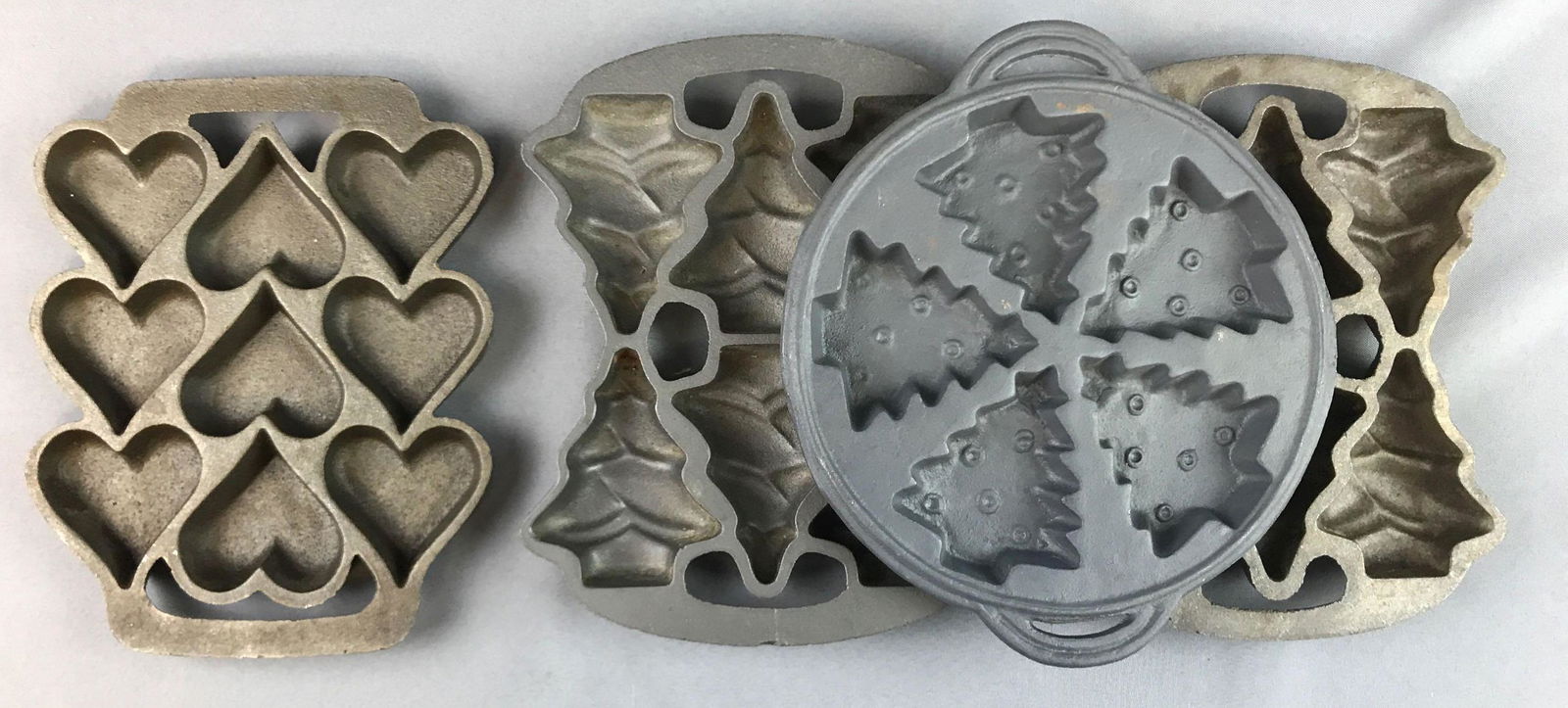 Group of 4 : Cast Iron Mold Pans: Heart and tree shapes. Largest is 10 inches long. One marked 1991 John Wright company