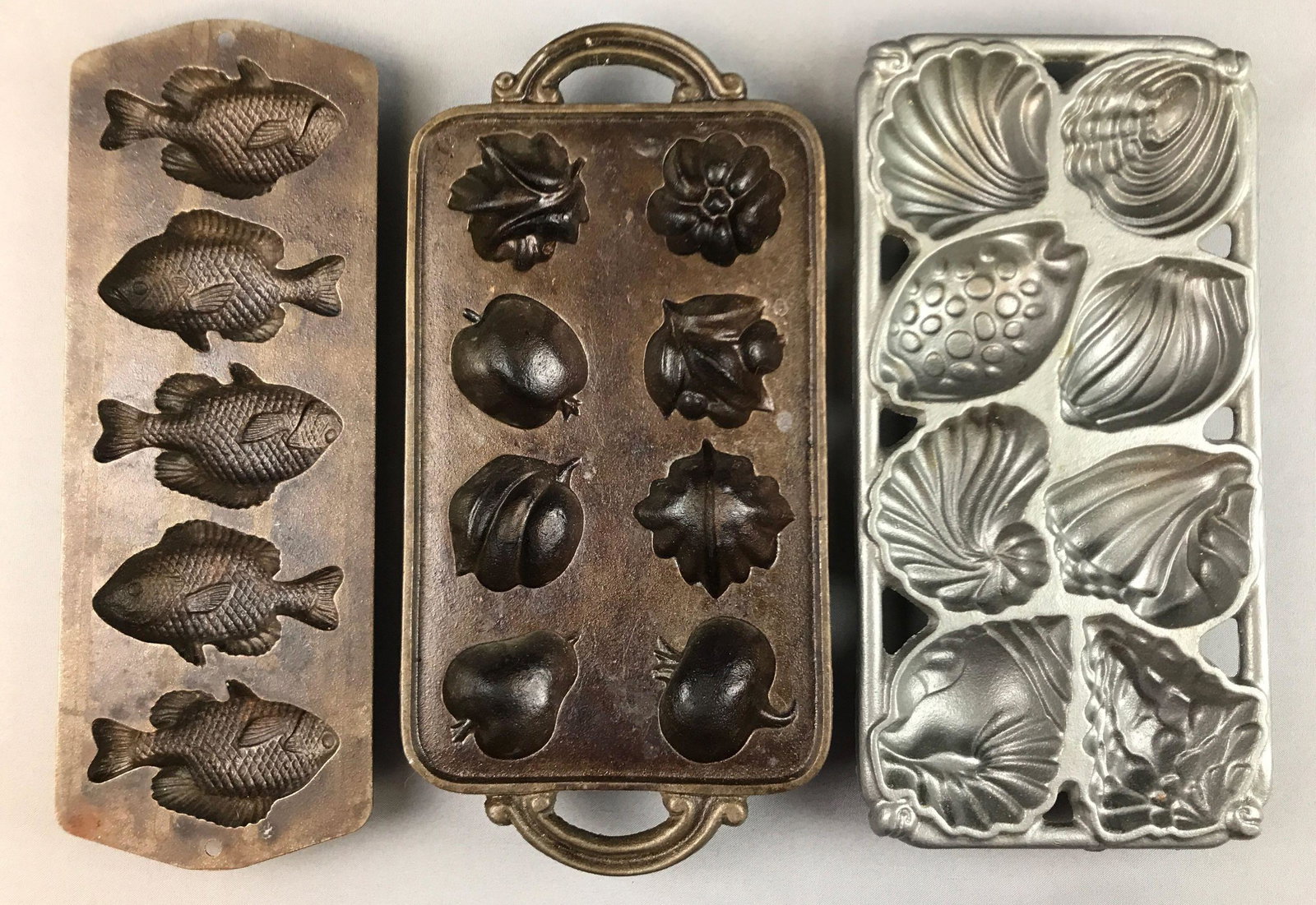 Group of 3 : Cast Iron Mold Pans: Largest is 15 inches long; fish, seashells, food forms