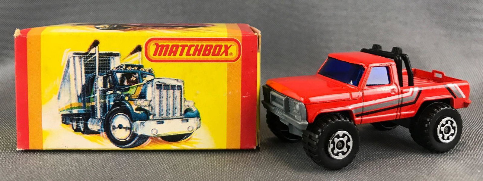 Matchbox No. 57 4x4 Mini Pick-Up Die-Cast Vehicle with: Red body, blue windows, BPW, stripes decals. A Lesney Product. Made in England