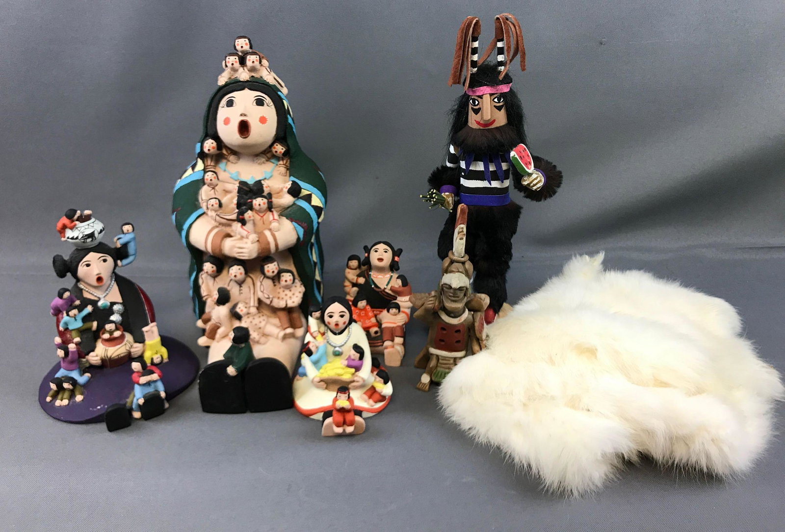 Group of Southwestern "Storyteller" Doll Figures, Hopi: This lot features four Southwestern inspired "Storyteller" Grandma Mother Figures and a colorful Hopi Kachina Hano Clown Souvenir with a slice of watermelon