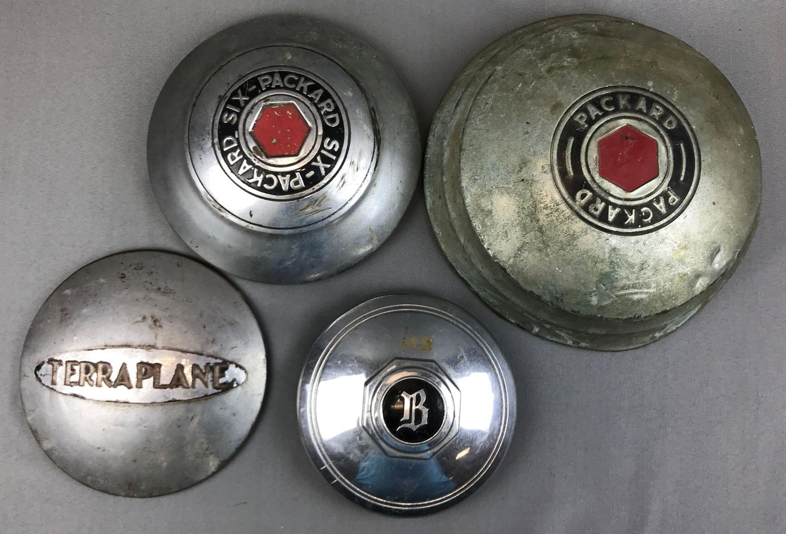 Group of 4 : Vintage Hubcaps - Packard, Terraplane, and: Largest has a 12 inch diameter; lot includes two Packard hubcaps, aTerraplanehubcapand a Buick 1930's B-centercap