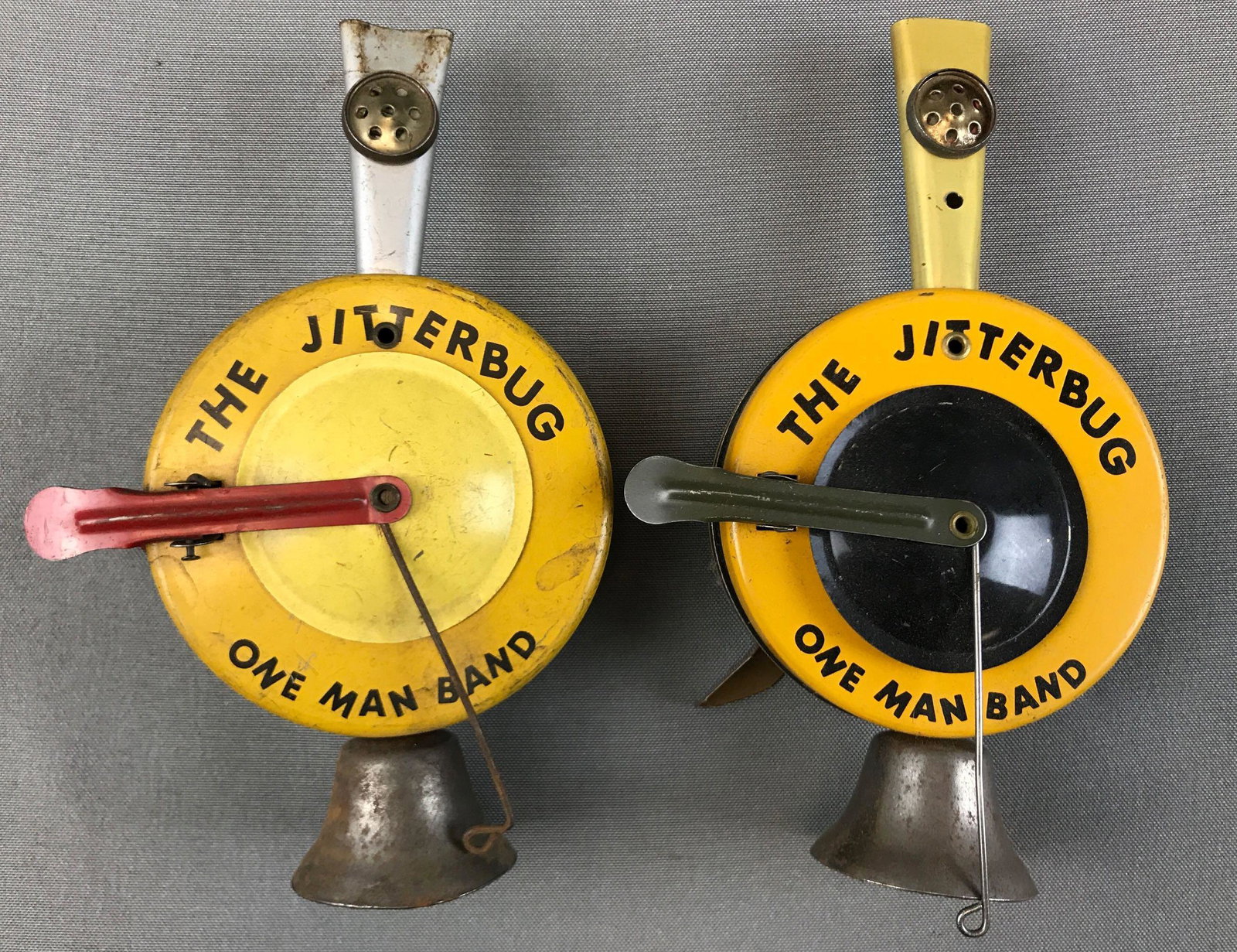 Lot of 2 Tin Noisemakers : "The Jitterbug One Man Band": 7 1/2 inches long