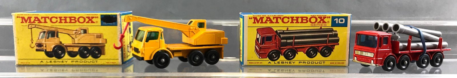 Group of 2 Matchbox die cast vehicles in original boxes: A Lesney Product. Includes no 63 Dodge Crane truck, no 10 pipe truck. No. 63 box is written on, number is blacked out.