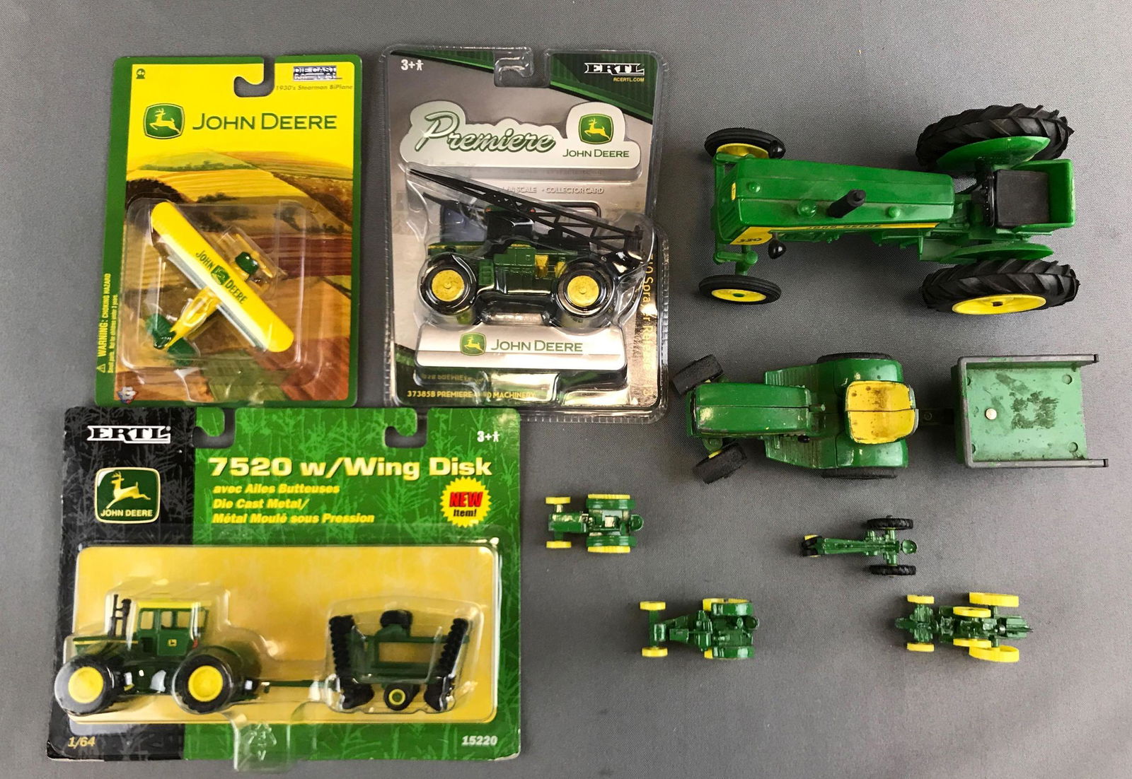 Group of John Deere die cast vehicles: One plastic, some new in package