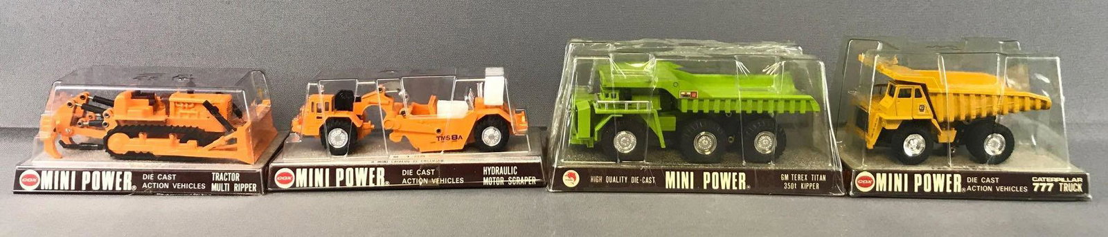 Group of 4 Shinsei Cox Mini Movers Die-Cast Vehicles in: Includes 32-Tractor Multi Ripper, 25-Hydraulic Motor Scraper, 608-GM Terex Titan 350t Kipper, and 40 Caterpillar 777 Truck