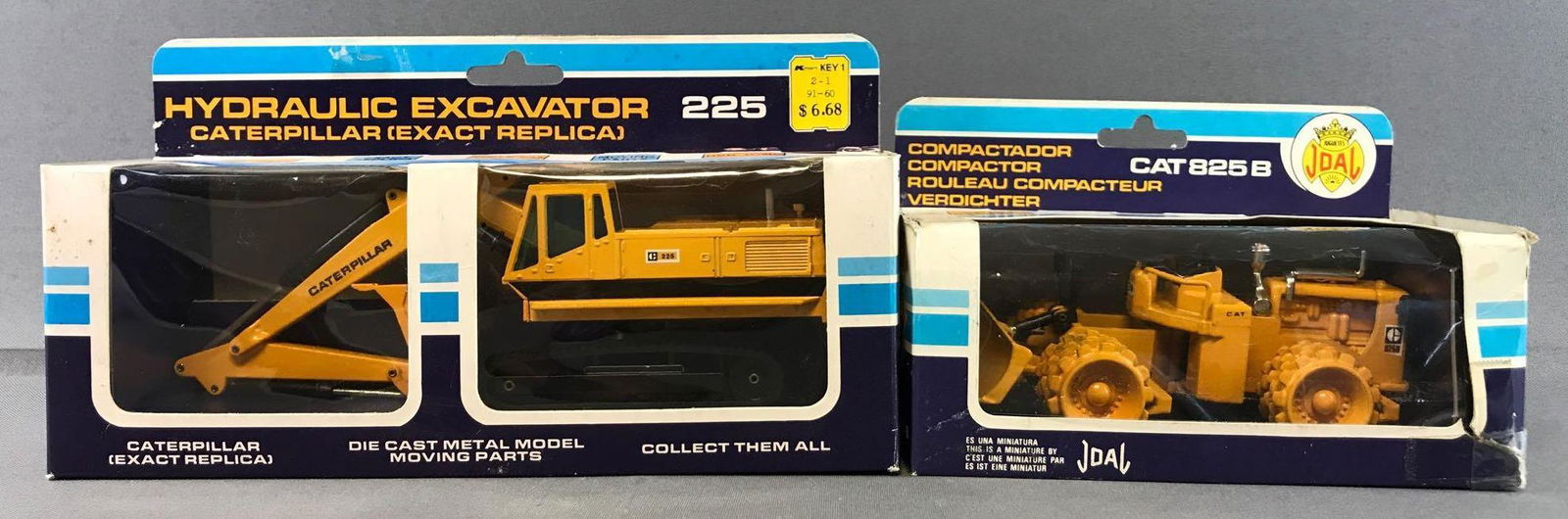Group of 2 Joal Die-Cast Vehicles in Original Packaging: Includes No. 216 Caterpillar 225 Hydraulic Excavator and No. 218 Caterpillar 825B Compactor. Some damage to packaging