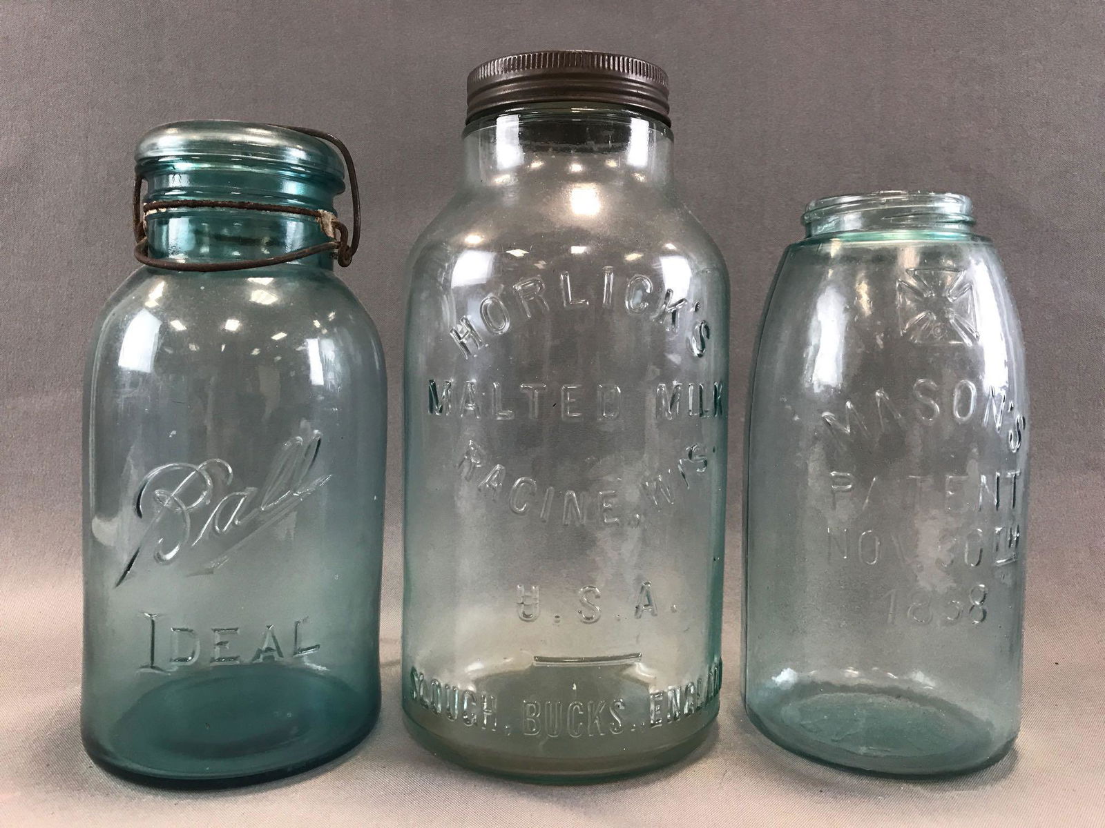 Group of 3: Antique Blue/Green Glass Jars: Largest is 11 inches, Horlick Malted Milk Racine, Wis. U.S.A. Slough, Bucks, England. The lot also includes Ball Ideal with glass lid and Hero Fruit Jar Co Masons - patent Nov 30th 1858 jar with Malte