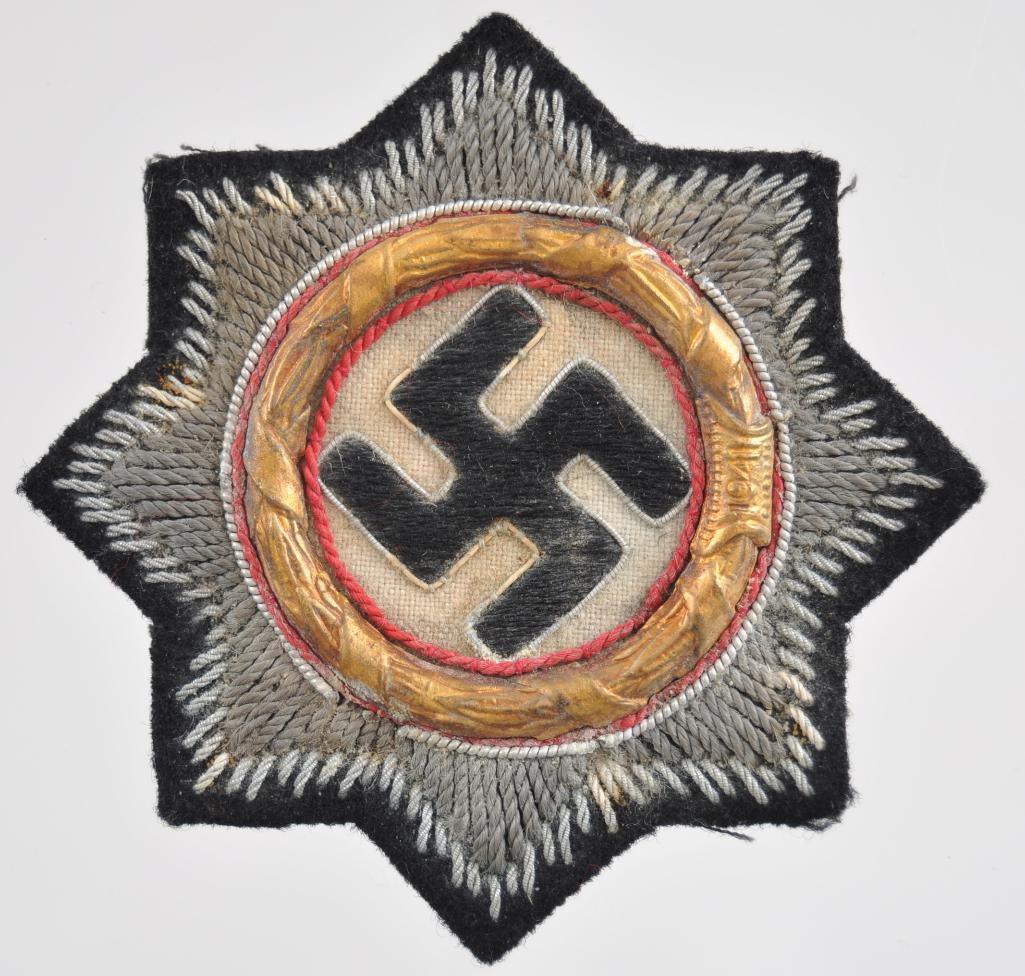 WW2 German Waffen SS Army Panzer Cloth German Cross in: Measures 2 7/8 in diameter. The front shows a swastika in the center surrounded by a round brass oak leaf wreath dated 1941 . There is an eight armed star in the back ground. Has black paper on the re
