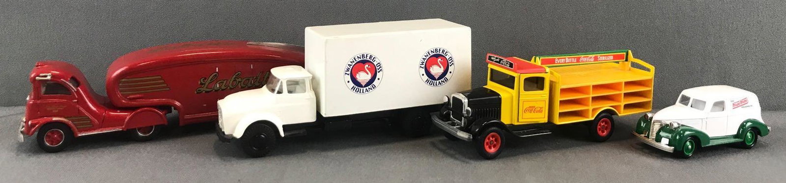 Group of 4 assorted die-cast delivery vehicles: 1986 World Expo Labatts Streamliner, Zwanenberg-OSS Holland, Siku Coca-Cola delivery truck includes 11 racks of bottles, and Lledo Krispy Kreme Promotional Model