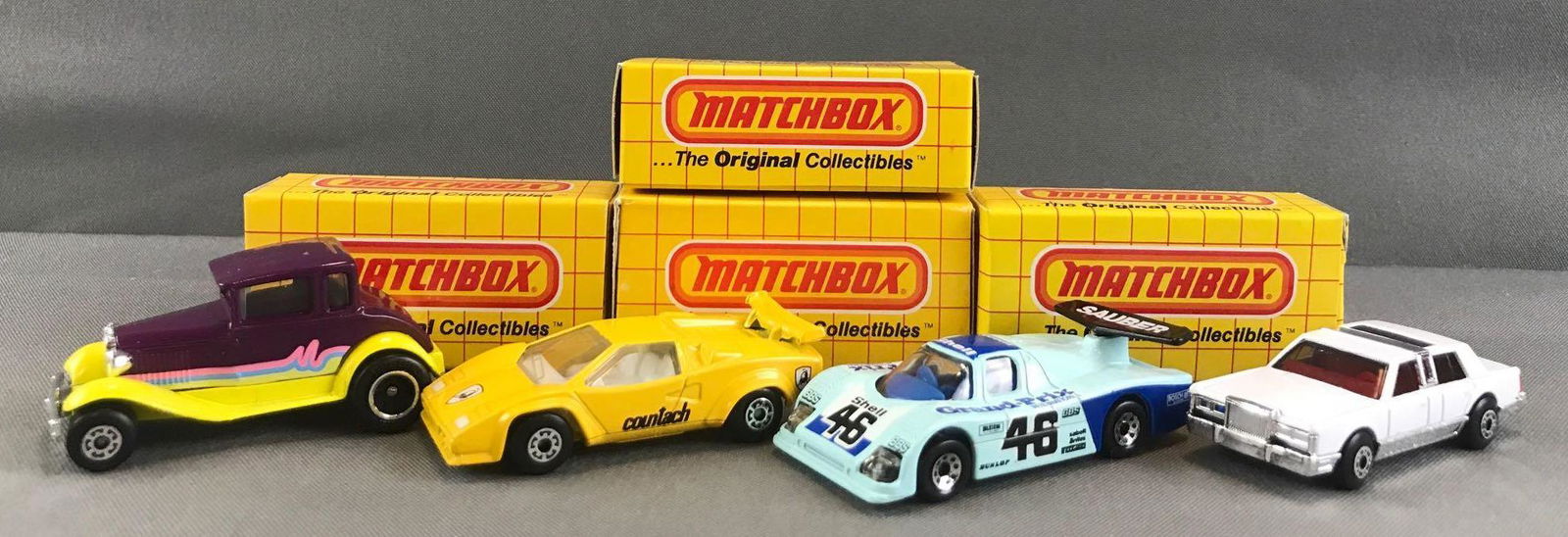 Group of 4 Matchbox die-cast vehicles in original boxes: Includes No. MB 73 Model A Hot Rod, No. MB 67 Lamborghini Countach, No. MB 66 Sauber Group C Racer, and MB 43 Lincoln Town Car. Made in Macau