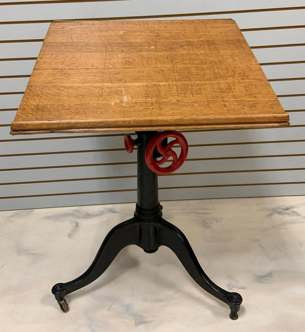 Antique Drafting Table w/ Oak Top and Cast Iron Base: Quarter sawn oak top with hinged top to lock in paper, adjustable. 26 x 22 x 36 inches. In-house shipping is not available for this lot; arrange third party shipping or pick up at our Gallery in Ottaw