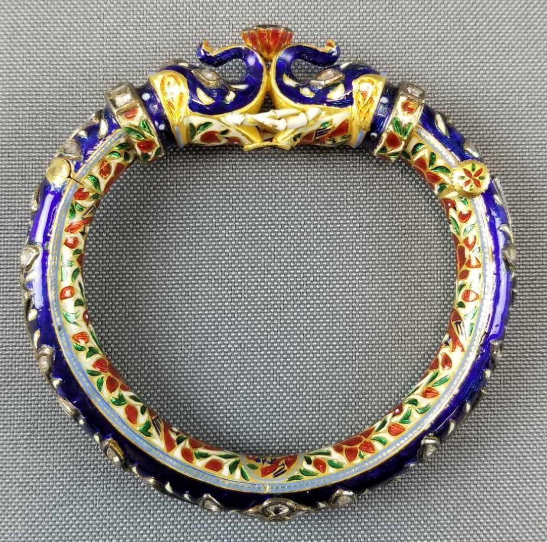 Indian Mughal hinged 22kt gold bracelet: Indian Mughal hinged 22kt gold bracelet with enamel decoration throughout inlaid and Polki diamonds of various shapes and sizes. Central depiction of two enamel decorated and diamond inlaid elephants 