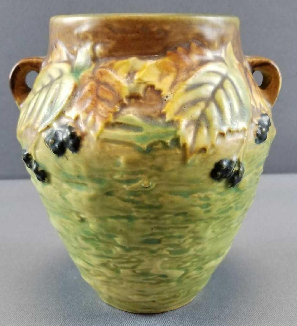 Roseville Pottery "Blackberry" Double Handle Vase: 6 inches tall. Vase retains its original foil label. Crazing, chip at lip and interior imperfection ridge