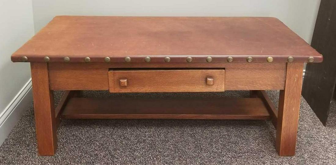 Vintage Arts and Crafts Leather Top Coffee Table: 50 x 29 x 19 1/2 inches; some wear and finish issues consistent with age and use. Drawer sticks. In-house shipping is not available for this lot; arrange third party shipping or pick up at our Gallery