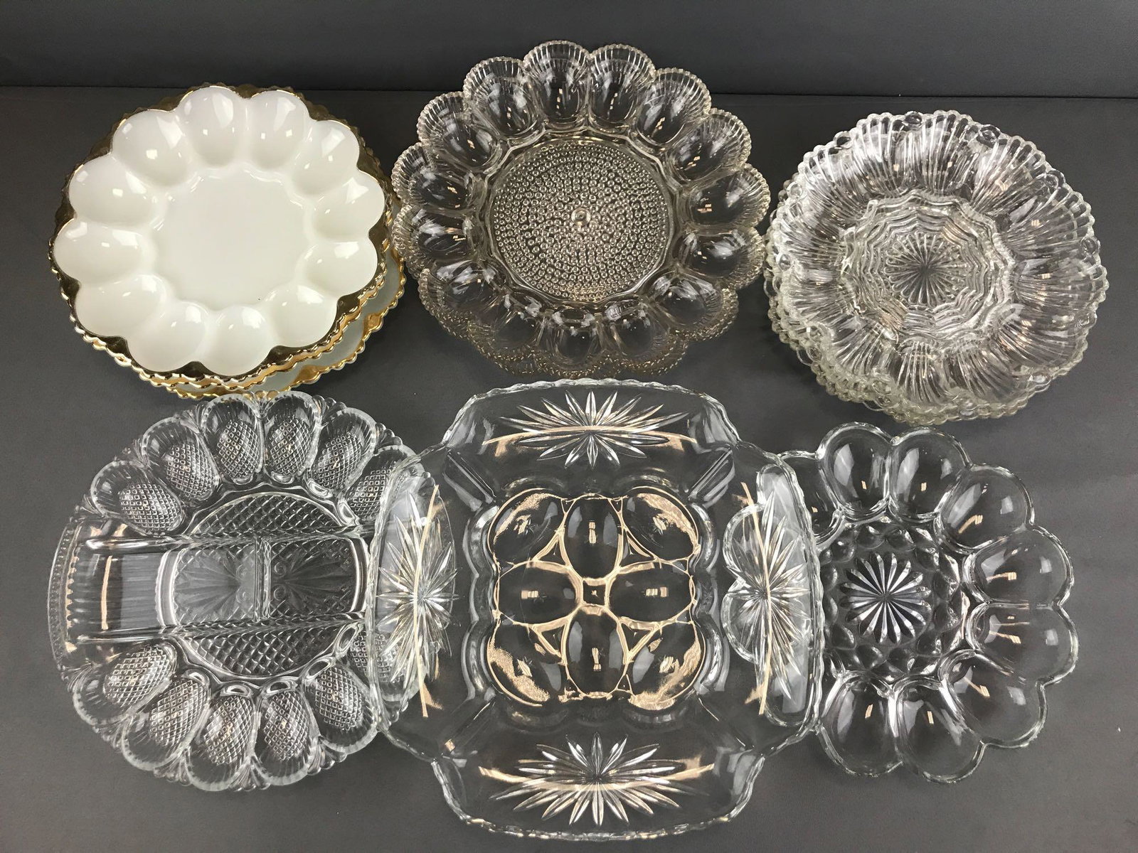 Group of 11 clear and milk glass egg plates: Indiana Glass, Anchor Hocking, and more. Largest is 12 inches