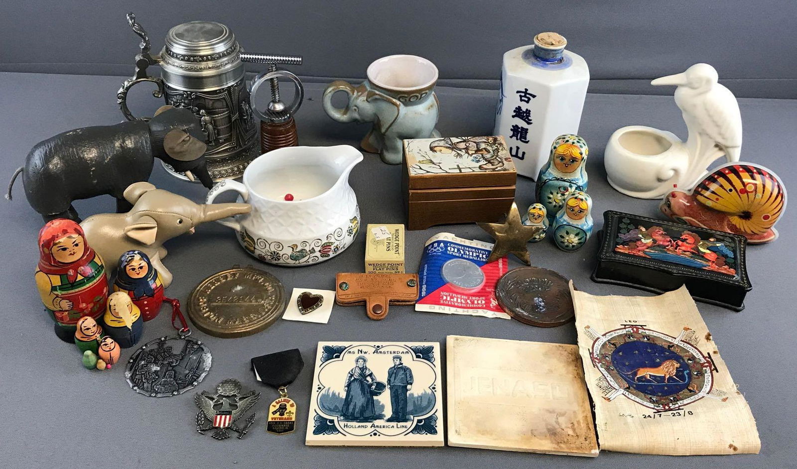 Group of 10 Plus Assorted Items: Includes Nesting Dolls, Music Boxes, Hersheyâ€™s Mfg Co Metal Cover, Military pins and more. Largest measures 6.75x4.75 inches.