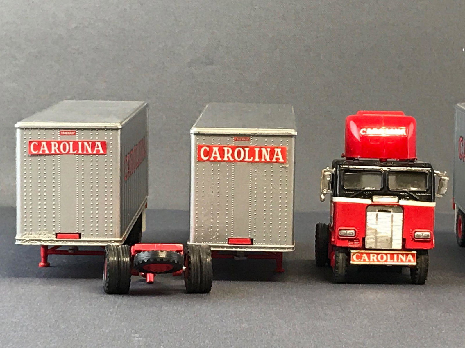 Group of 2 Tonkin Replicas Carolina die-cast tractor: Measures 15.25x3x2 inches. Missing antenna on one tractor and broken plastic weld on another. Wear consistent with age.