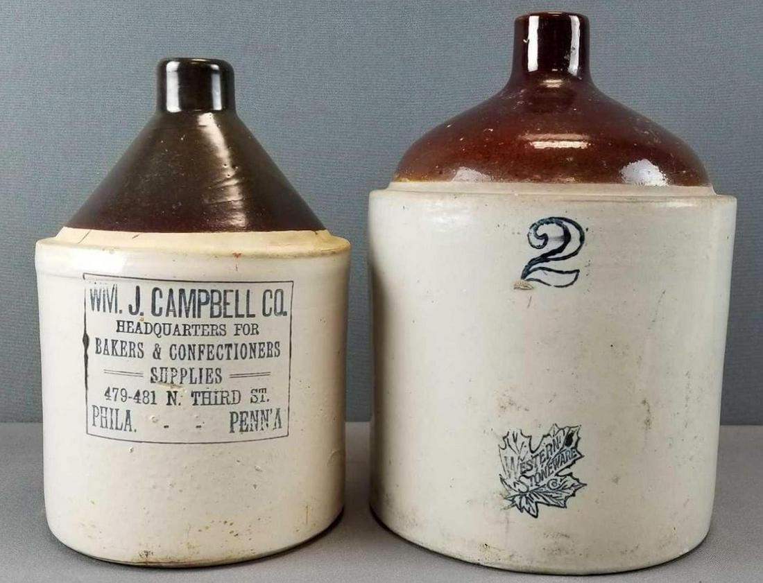 2 antique stoneware jugs: Larger is 2 gallon, 13 inches tall, advertising jug and western.