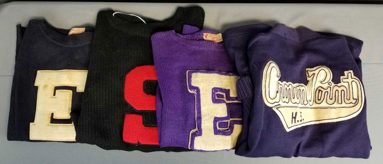 Group of 4 vintage letterman sweaters: 3 pullover, one cardigan. Purple, black, navy. Need cleaning. Used condition