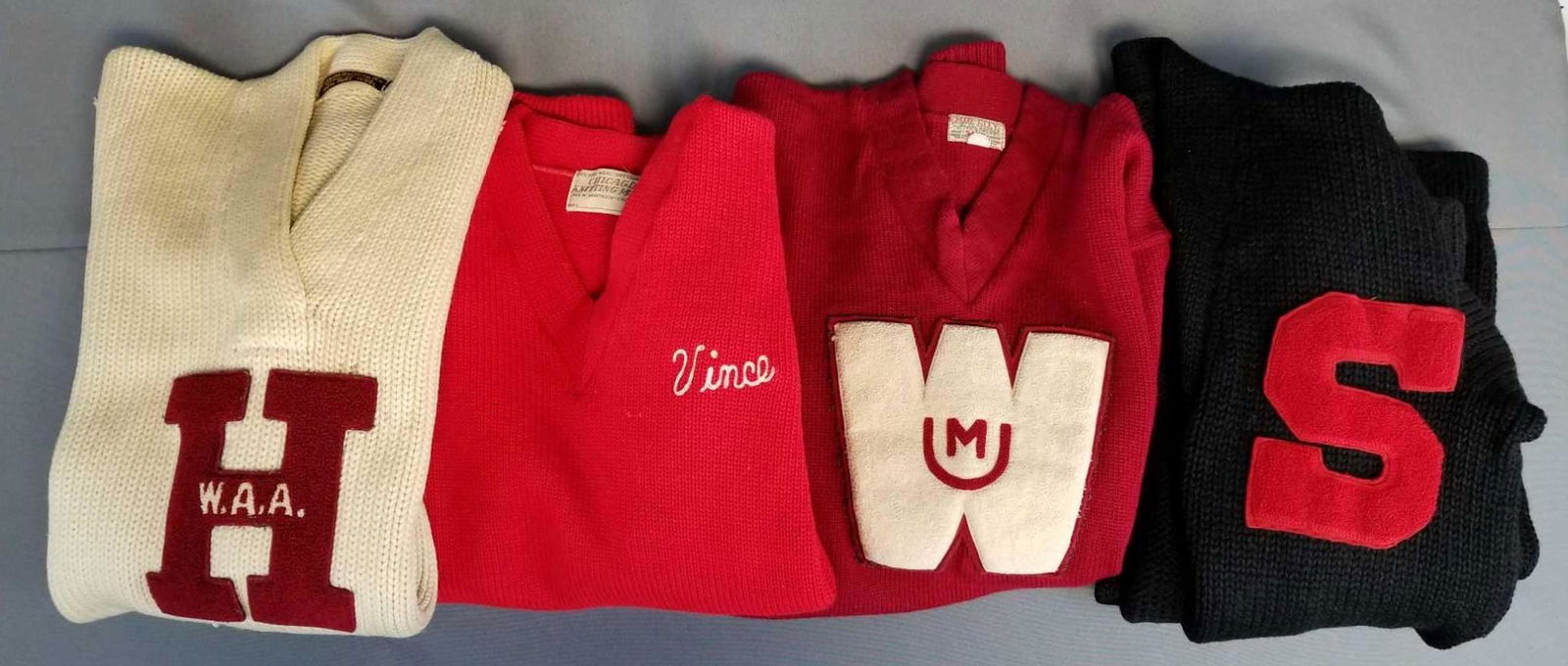 Group of 4 vintage letterman varsity sweaters: Red, black, cream. 3 pullover, 1 cardigan. All have wear or holes. Need cleaning.