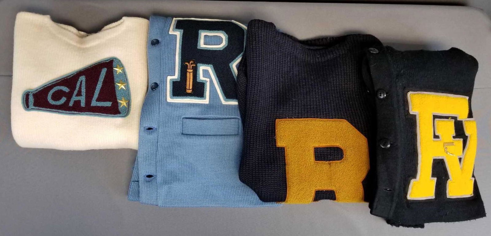 Group of 4 vintage letterman varsity sweaters: Black, navy, blue, cream. All have some wear or holes.