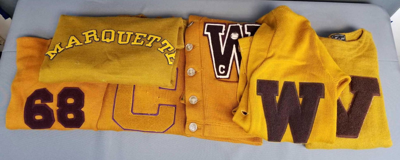 Group of 6 vintage letterman varsity sweaters: One Marquette, all are gold. Some pullover, some cardigan. All have wear/holes