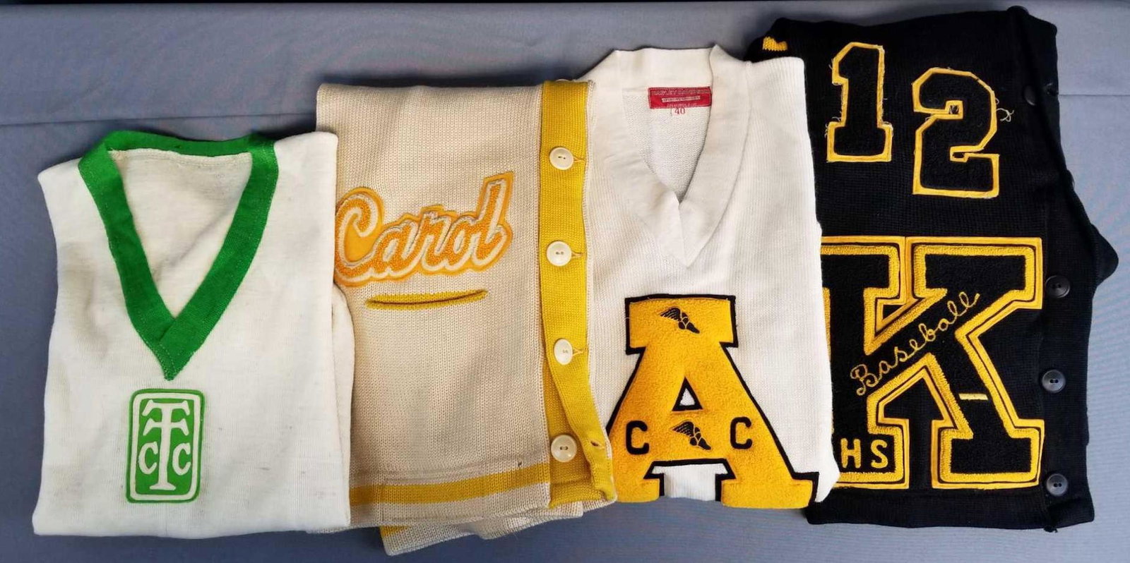 Group of vintage sweaters, letterman and more: Black, cream. All have some wear, stains, or holes.