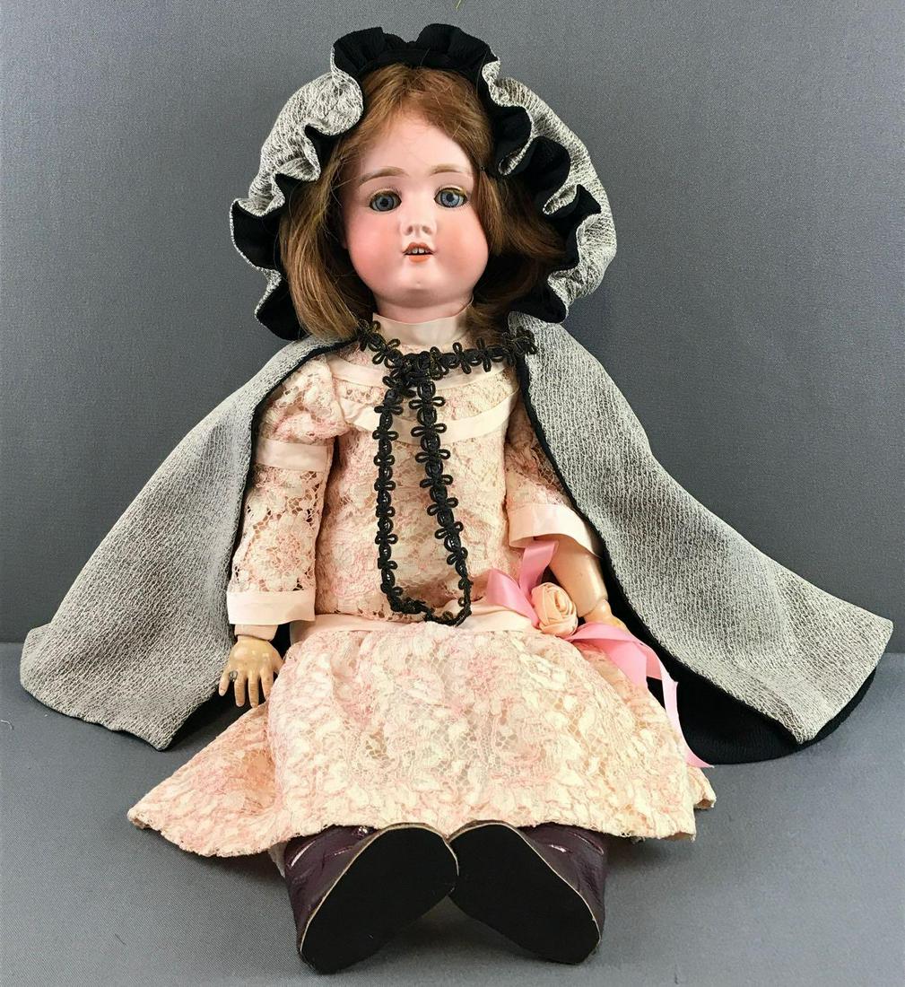 Antique 22 inch German bisque doll Adolf Wislizenus: Marked Germany, A. Ws. II, blue stationary glass eyes with painted and affixed lashes. Red hair wig. Open mouth with teeth. Lace cream and pink dress. Composition and wood jointed body and hands. Hand