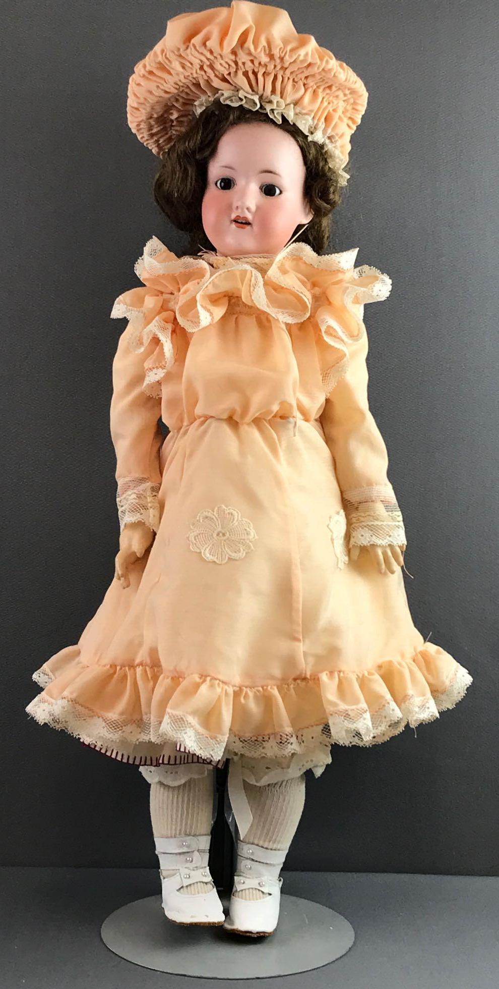 Antique 24 inch German bisque doll Marseille: Armand Marseille 390n, DRCM 246/1 AGM. Brown stationary glass eyes with painted lashes, open mouth with teeth. Composition jointed body. Peach and lace dress, under garments, hat, stockings and shoes.