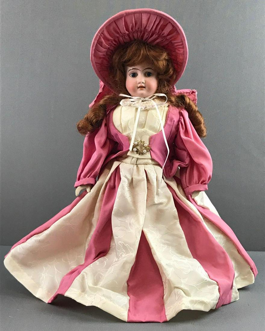 Antique 16 inch German bisque doll Marseille: 3/0, AM, CVD 93 G DEP. Shoulder head, blue glass stationary eyes, open mouth, fabric body with bisque arms and legs. Pink and cream dress and hat, bloomers, shoes. Minor paint loss on nose, fingers ar
