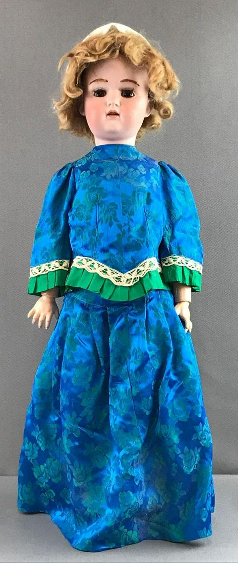 Antique 27 inch German bisque doll Kestner: K 14, JDK 216. Socket head, brown sleep eyes with applied lashes, open mouth with teeth, composition and wood jointed body. Blue and green brocade dress, under garments, socks, hat. Mohair wig and eye