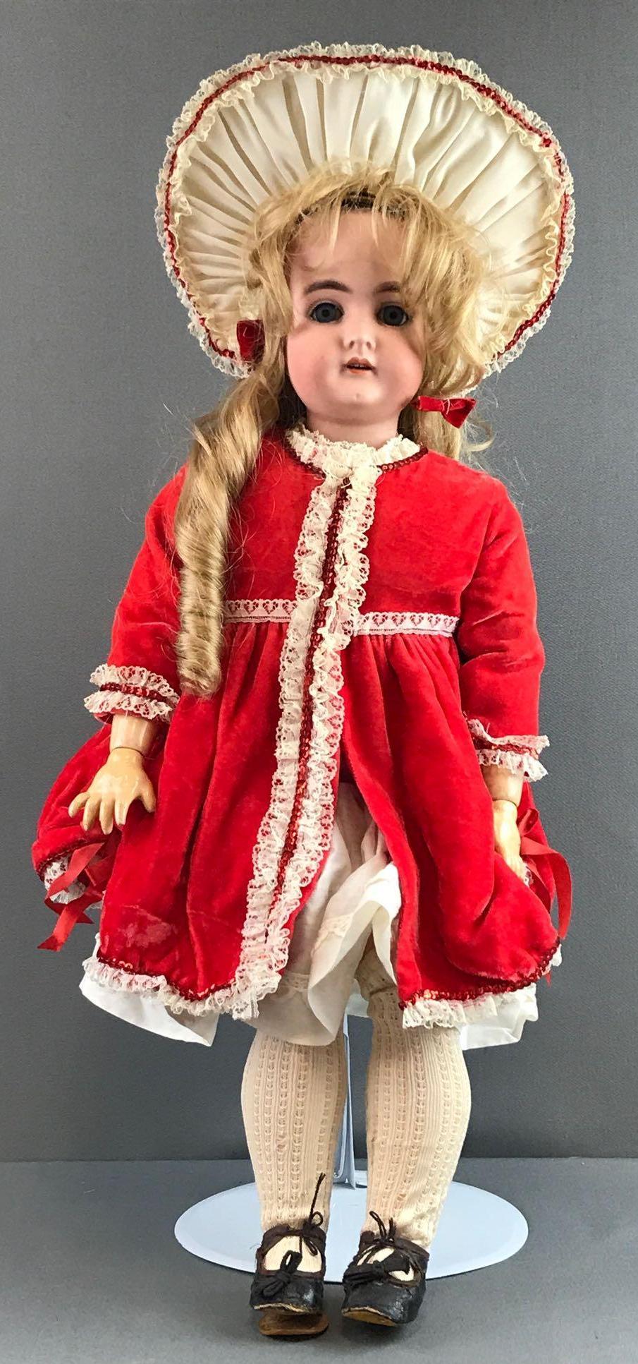 Antique 24.5 inch German bisque doll Karl Hartmann: 30, K H, 3. Socket head, blue glass eyes with painted lashes, composition and wood jointed body. Red with lace dress, hat, under garments, stockings, shoes. Paint loss, some chipping and wear, especia