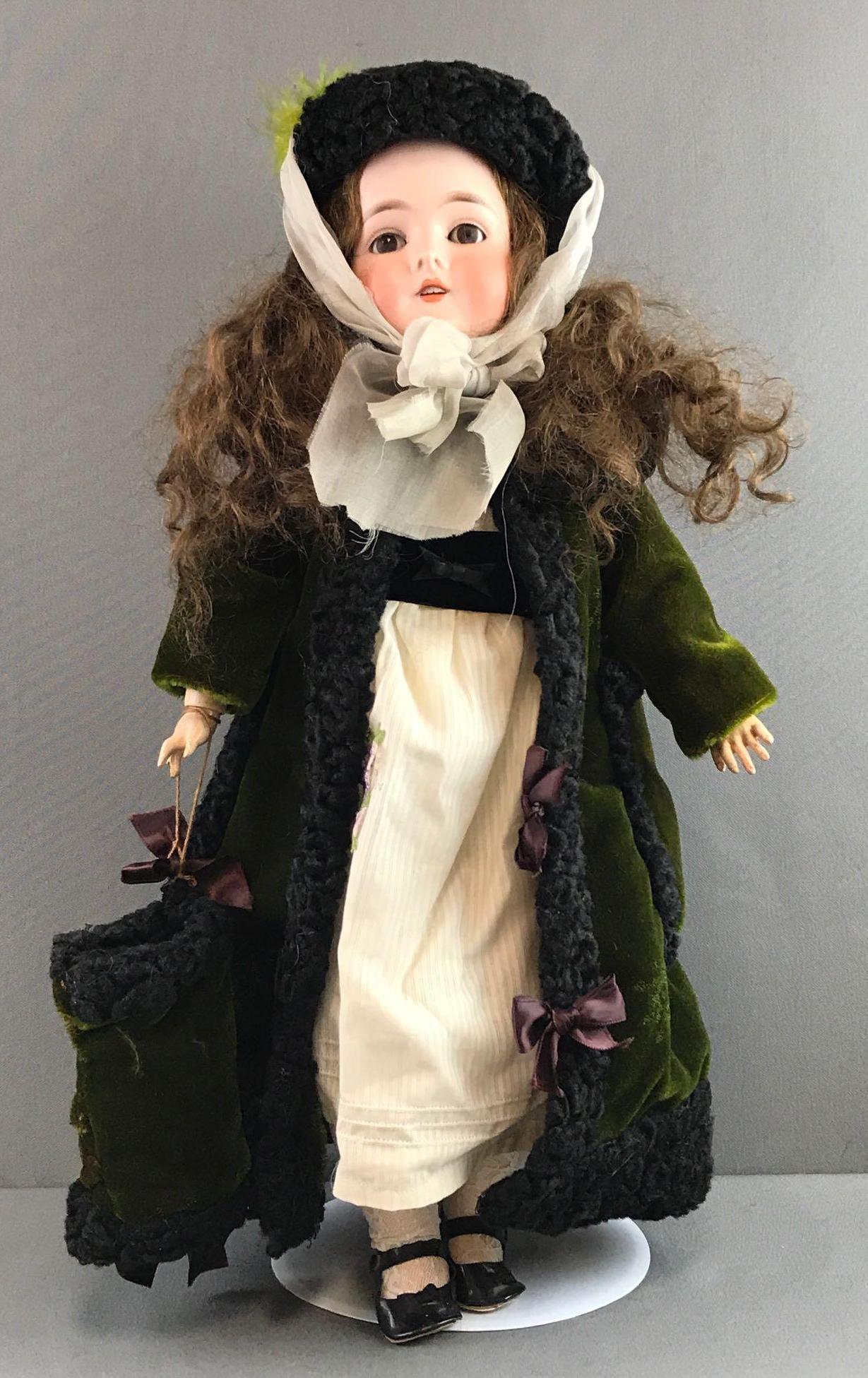 Antique 24 inch German bisque doll Marseille: 29, Queen Louise, 100. Brown glass eyes with painted lashes, socket head, open mouth with teeth, composition and wood jointed body. White dress, green coat with wool trim, hat, and muff, under garment