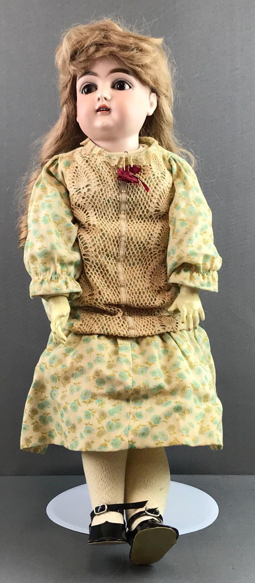 Antique 23 inch German bisque doll Kestner: K 13, made in Germany. Socket head, brown sleep eyes with painted lashes, composition and wood body, open mouth with teeth. Floral dress, under garments, stockings, shoes. Blonde human hair replacemen