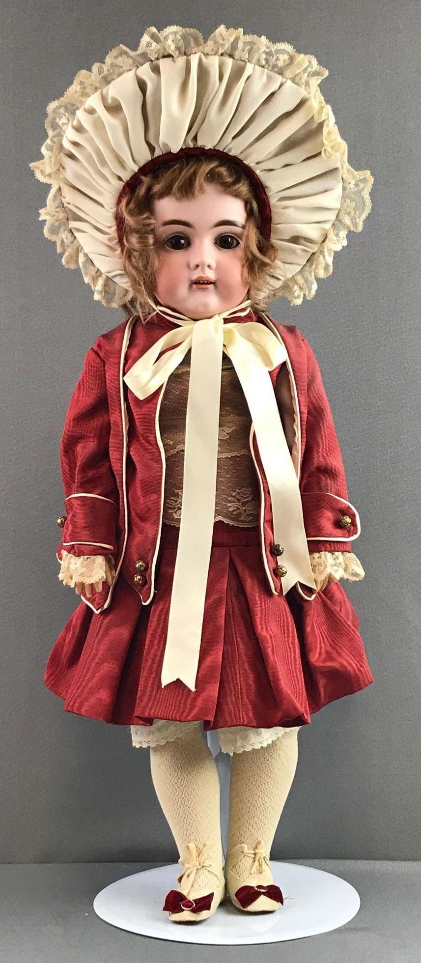 Antique 22 inch German bisque doll Kestner: H Made in Germany 12, 161. Socket head, brown sleep eyes with painted lashes, open mouth with teeth, composition and wood body- appears to be newer/refinished. Maroon dress, jacket, under garments, st