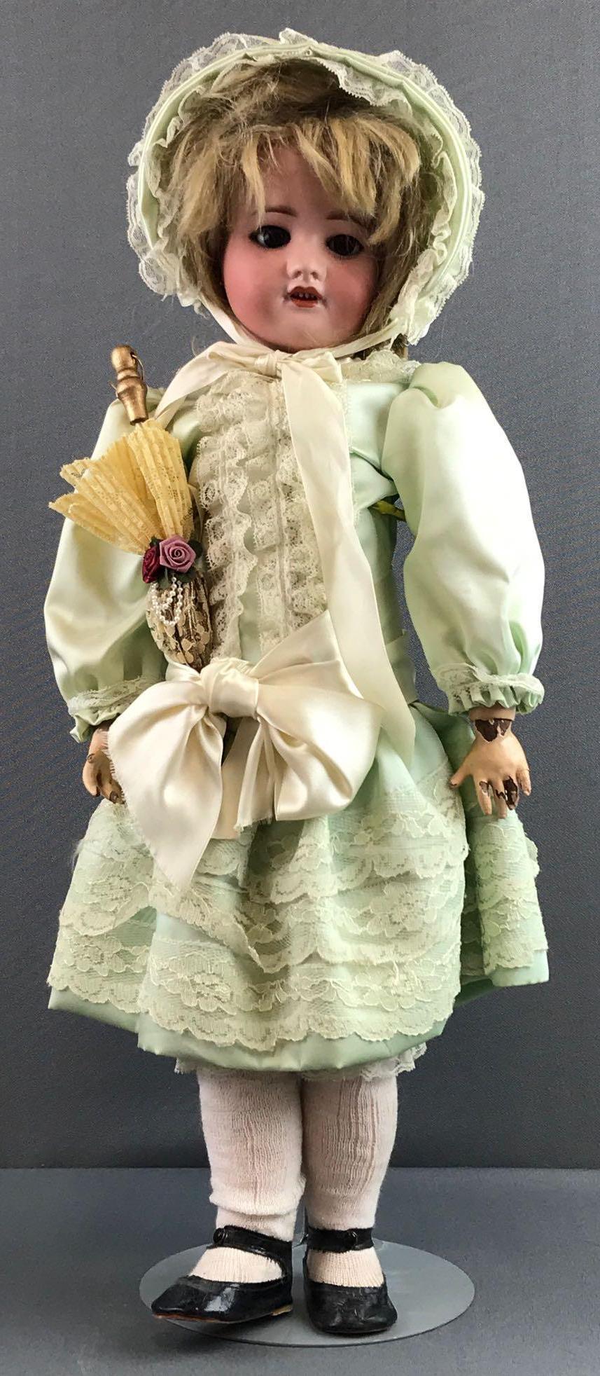Antique 21.5 inch French bisque doll SFBJ: Back of head reads D SFBJ, 60 paris, 5. Socket head, brown sleep eyes with painted and applied lashes, open mouth with teeth, composition jointed body. Light green dress with lace, bonnet, under garme