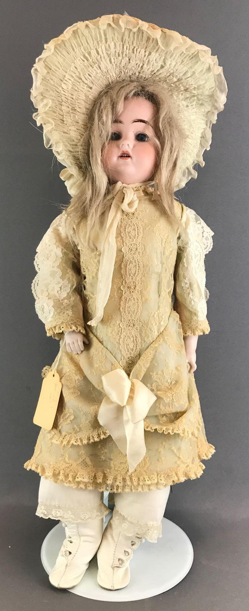 Antique 24 inch German bisque doll marked Special: Back of head reads Special 4. Shoulder head, blue sleep eyes with painted lashes, open mouth with teeth, leather body with bisque hands. Ivory lace dress, hat, under garments, socks, boots. Blonde hai